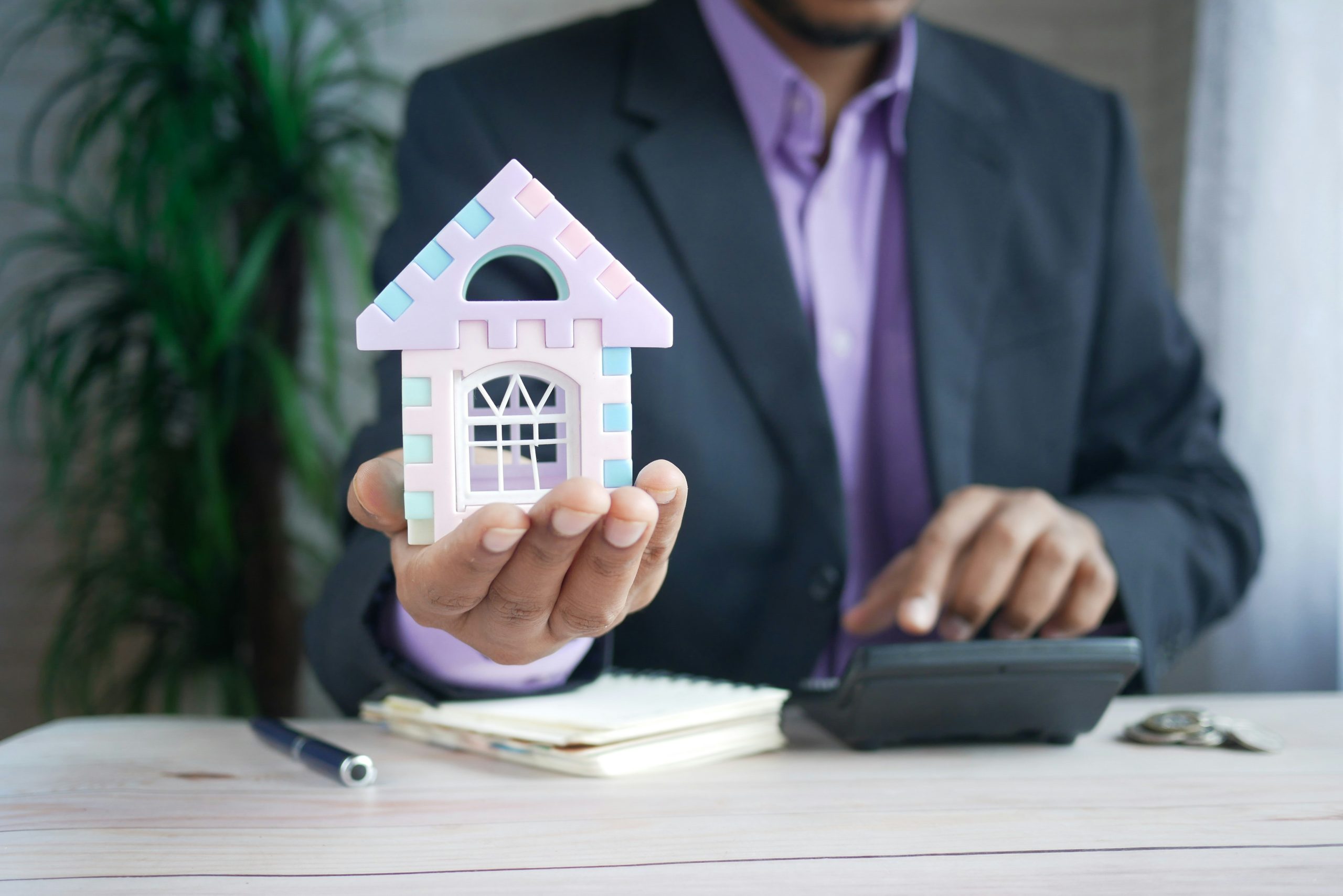 a man with a calculator and home model